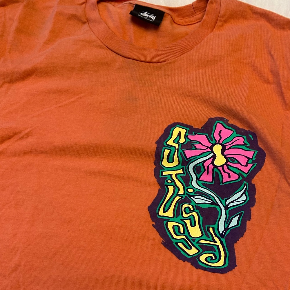 Stussy Orange Short Sleeve Tee with Pink Flower Graphic